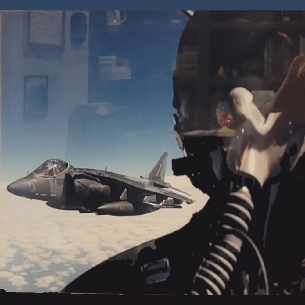 Pilot in single seat attack jet (Harrier) with another Harrier on his right wing